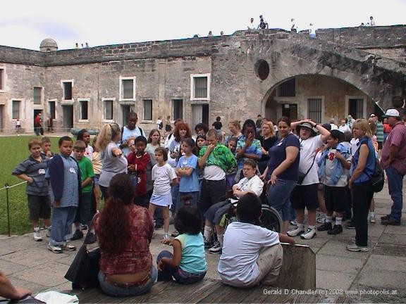 Crowd of tourists listening to lecture about Castillo de San Marcos